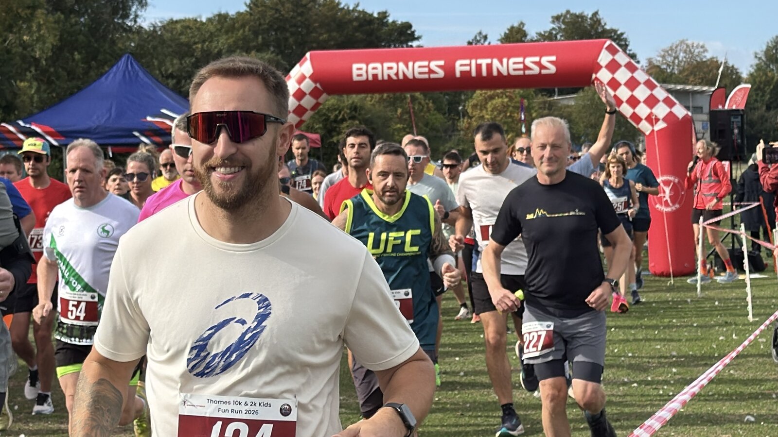Runners set off beneath the Barnes Fitness start arch at Thames 10k